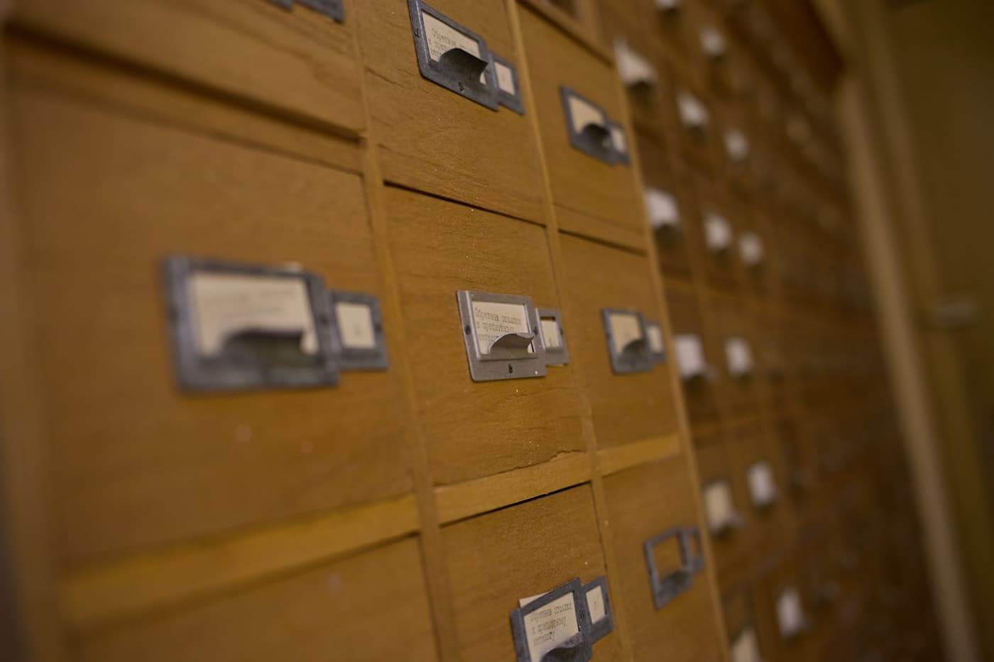 A wall of wooden card-catalogue drawers, each with a handwritten index label.